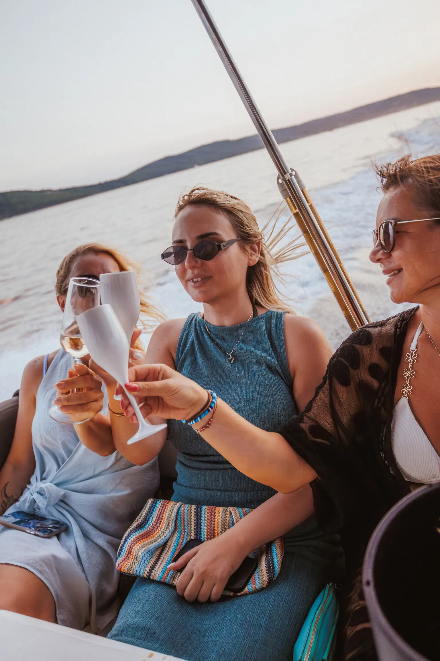 Three friends raising glasses aboard a private boat off the Dalmatian coast