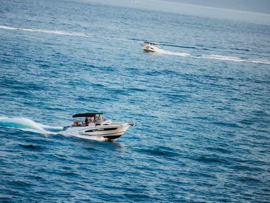 Our boat carrying guests at speed across open blue water