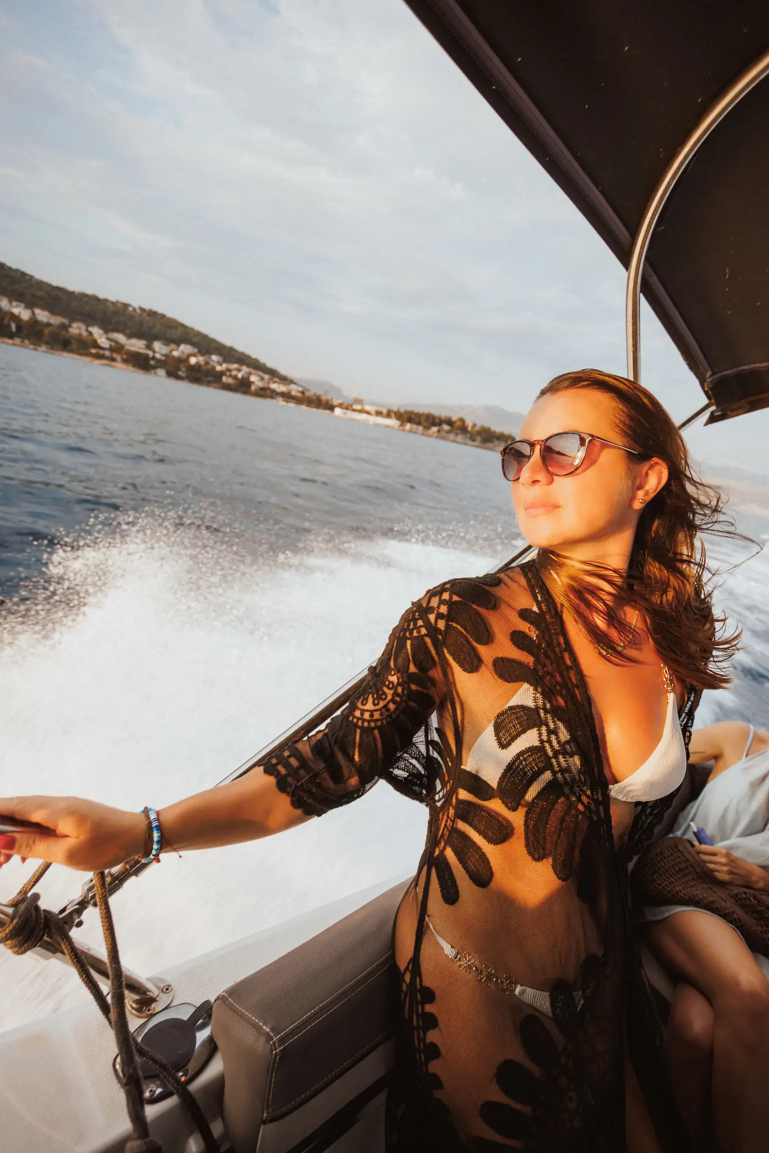 Guests relaxing with drinks on a private boat in warm evening light