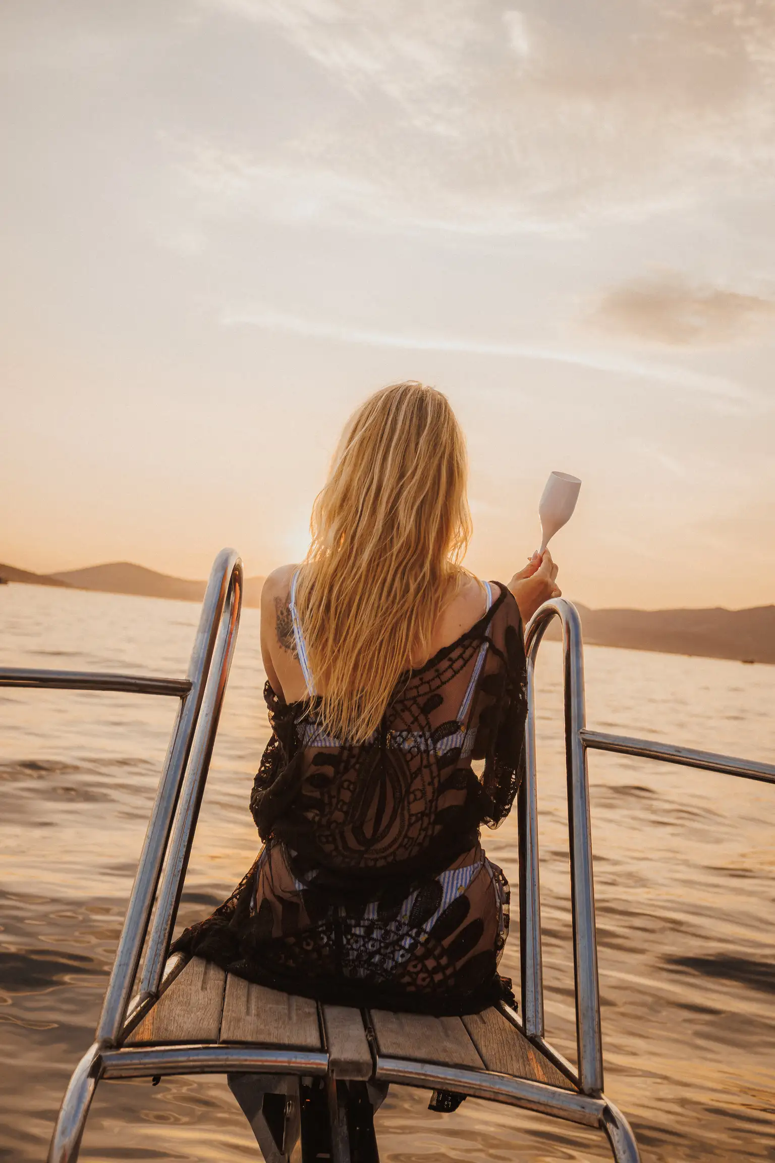 Guests relaxing on the bow of a private boat at sunset